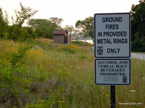 Douglas State Fishing Lake - Wildflowers - Wildflowers bloom in profusion at Douglas State Fishing Lake. Here are some signs, as well as a view of one of the restroom facilities in the background.