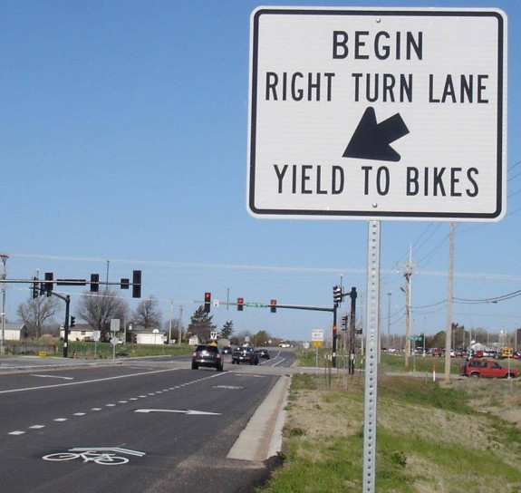 It can be hard to safely mix right turn lanes with bike lanes. The city made a good decision to use sharrows and signs to make clear that cyclists going straight have the right of way.